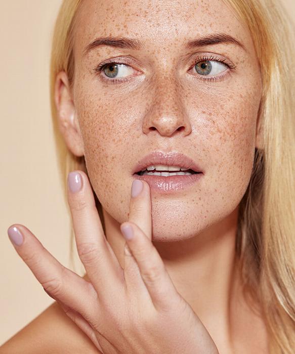 Lady with lots of freckles wiping lip